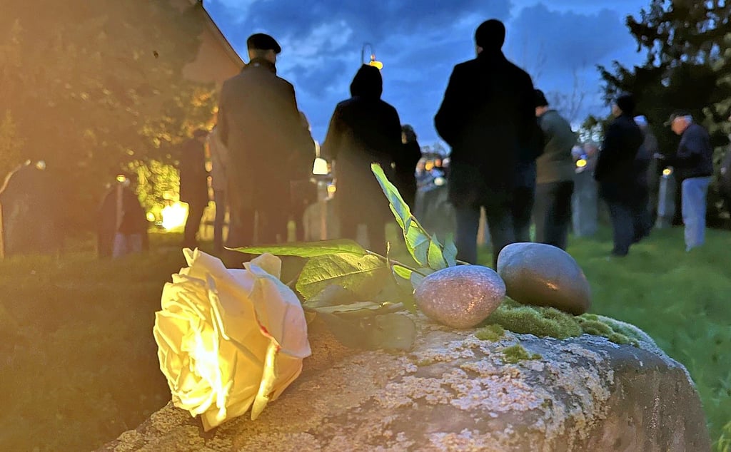 Eine weiße Rose und Steine als Zeichen der Erinnerung und des Nichtvergessens werden am Mittwochabend auf einem Grabstein auf dem jüdischen Friedhof in Tangermünde abgelegt.