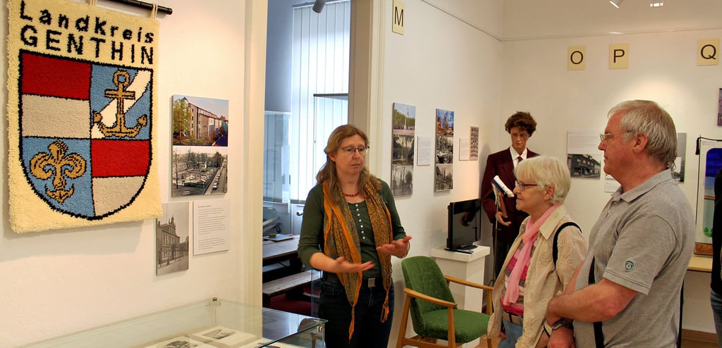 Museumsleiterin Antonia Beran (l.) zeigt den Stadtsenioren die Sonderausstellung zu 850 Jahren Genthin.