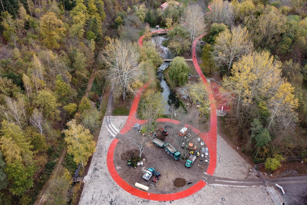 Blick auf die Baustelle von einem Themengarten im "Spiel- und Sportpark" mit roter Laufbahn.