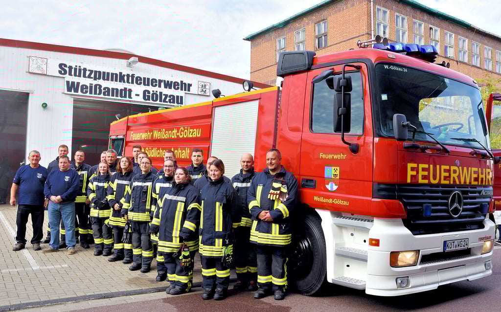 Feuerwehrleute aus Weißandt-Gölzau stehen vor ihrem Großtanklöschfahrzeug, dessen Tank 12.000 Liter Wasser fasst.