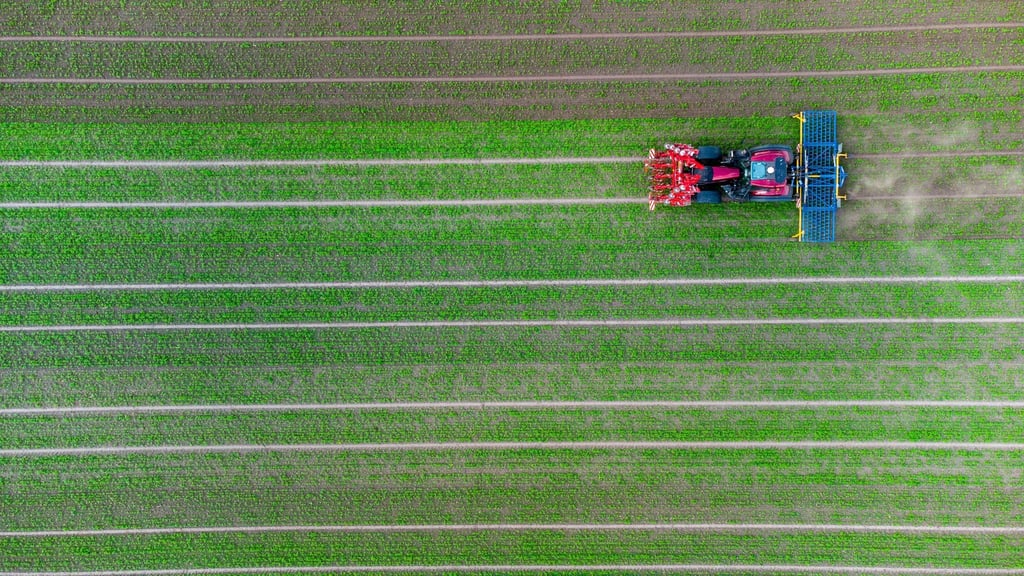 Ein Landwirt fährt mit seinem Trecker über ein Feld.