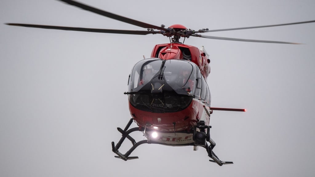 Ein Rettungshubschrauber fliegt über den Flugplatz eines Krankenhauses.