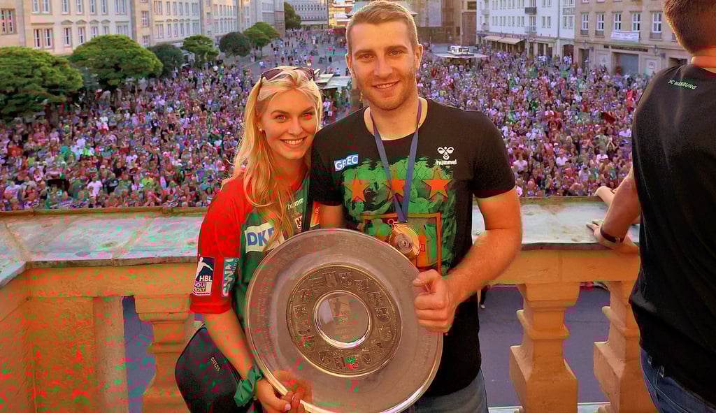 Lukas Mertens mit Freundin Louisa und der Meisterschale auf dem Magdeburger Rathausbalkon.