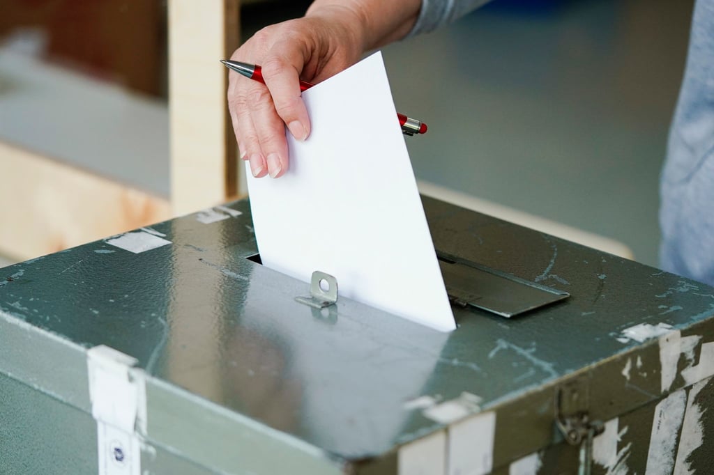 Eine Wählerin wirft in einem Wahllokal ihren Stimmzettel in eine Wahlurne.