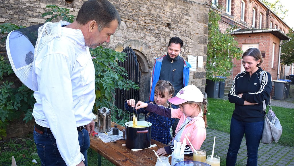 Die sechsjährige Alice (vorn) und ihre Freundin Emilie hatten beim herbstlichen Saisonausklang am Museum am Stand des Imkers Maik Hackert viel Spaß beim Kerzenziehen.