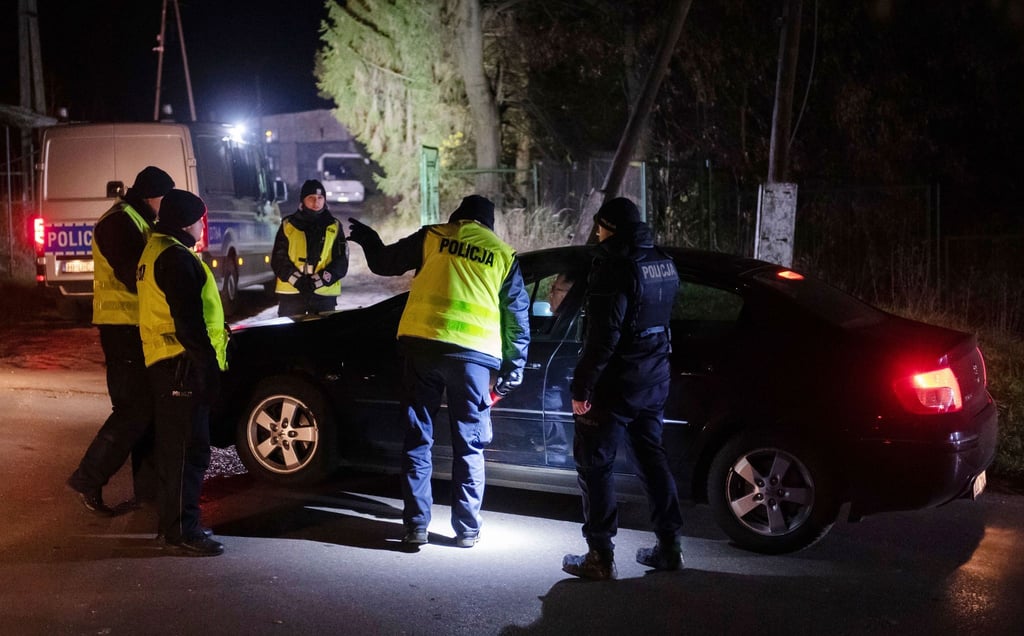 Polizisten versammeln sich vor einem Getreidelager in Przewodow im Südosten Polens. Nach einer Explosion mit zwei Toten hat Polen einen Teil seiner Streitkräfte in erhöhte Bereitschaft versetzt.