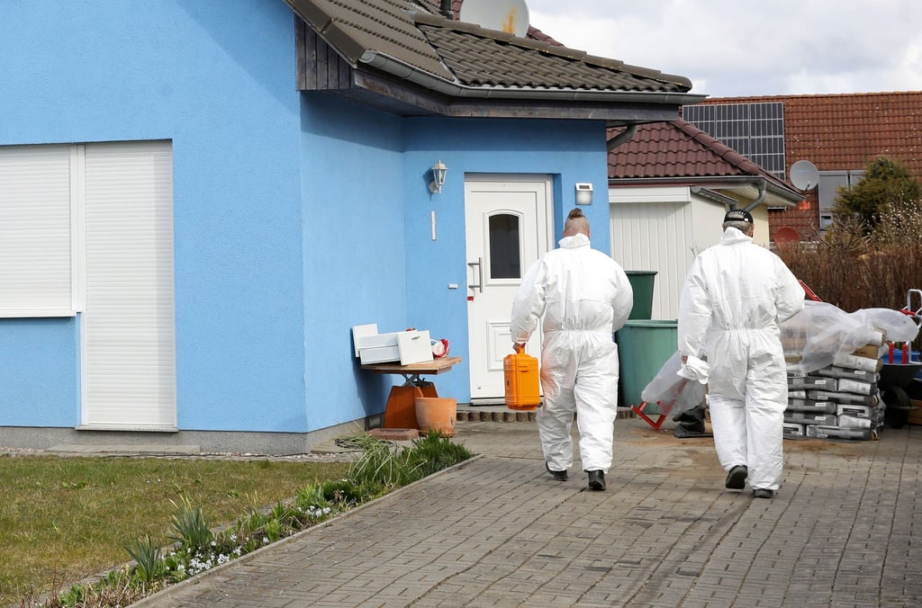 Mitarbeiter der Kriminaltechnik gehen in das Haus in Rövershagen, in dem drei Menschen getötet worden sein sollen.
