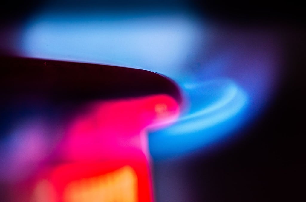 Die Flamme eines Gasherdes brennt in einer Küche.