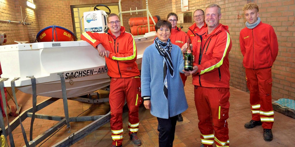 Annett Görlich, Vorstandsmitglied der Sparkasse Mansfeld-Südharz, überbrachte der DLRG-Ortsgruppe Hettstedt neben der Geldspende auch eine Flasche Sekt, mit der das Motorboot „Sachsen-Anhalt“ nach Fertigstellung erneut getauft werden soll.