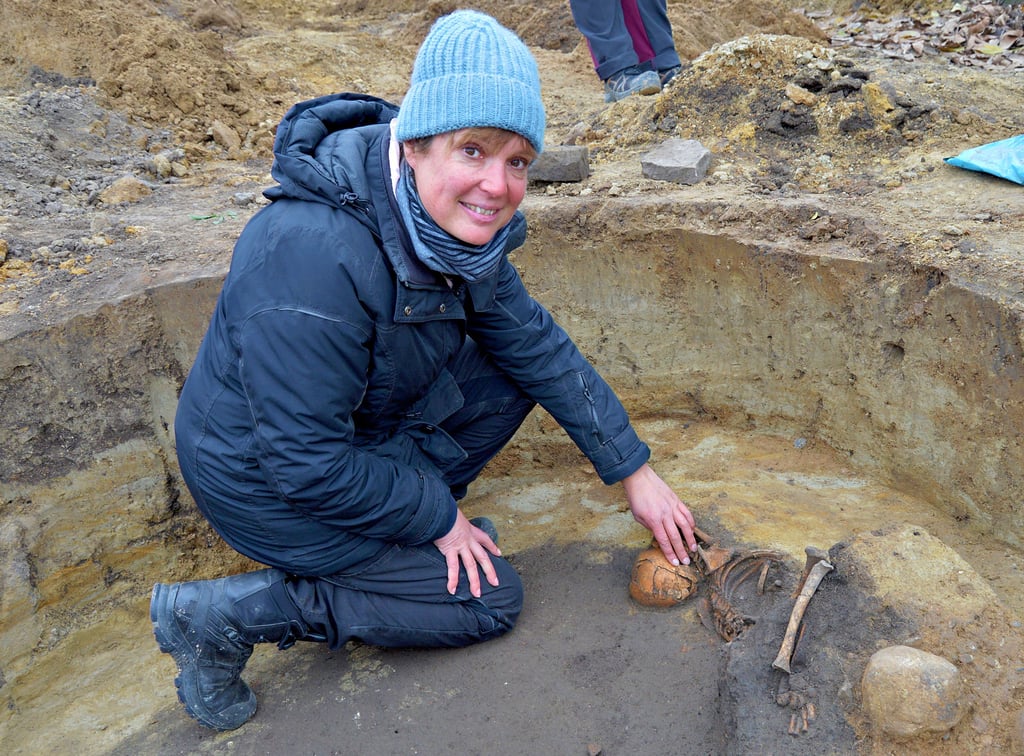 Grabungsleiterin Xandra Dalidowski befindet sich in einer einstigen Abfallgrube, in der das Skelett eines etwa achtjährigen Kindes entdeckt wurde, das wahrscheinlich vor 2.700 Jahren lebte.