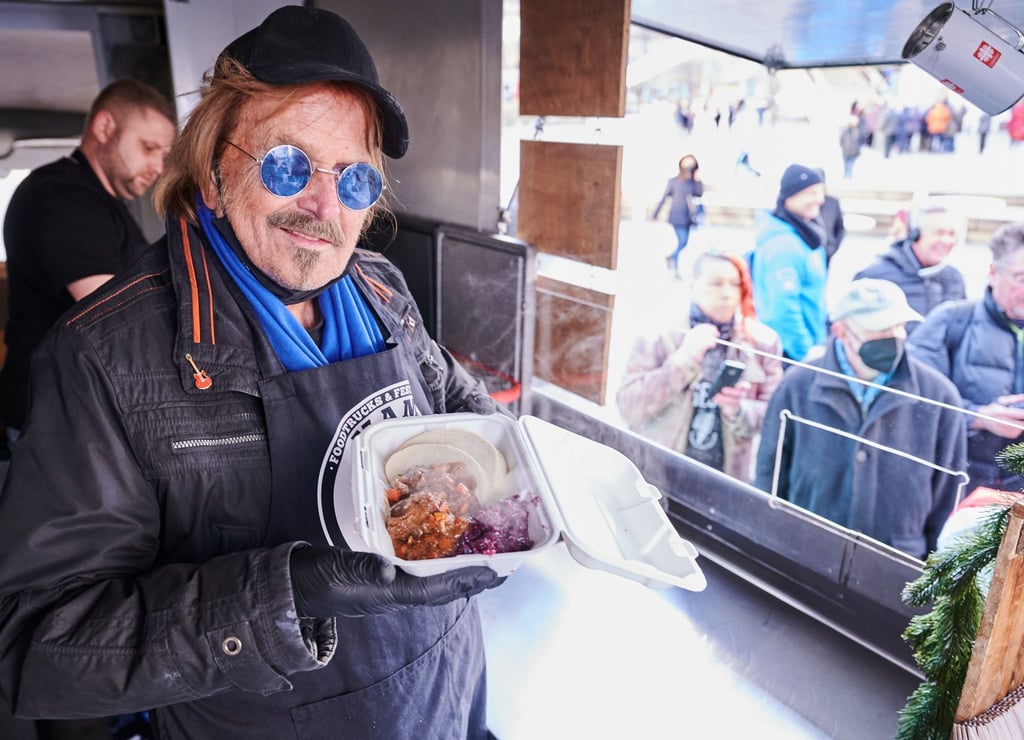 Frank Zander steht im Caritas-Foodtruck und verteilt warme Mahlzeiten an Obdachlose und bedürftige Menschen auf dem Alexanderplatz in Berlin.