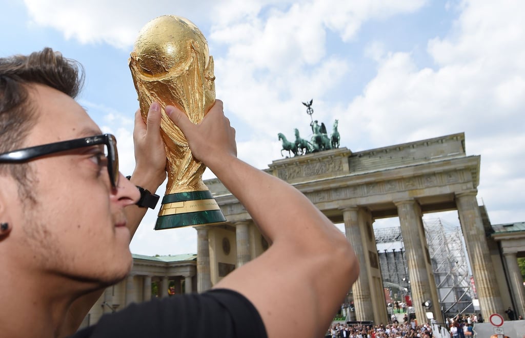 Traut dem DFB-Team bei der WM einiges zu: Der damalige Nationalspieler Mesut Özil mit WM-Pokal 2014 vor dem Brandenburger Tor.