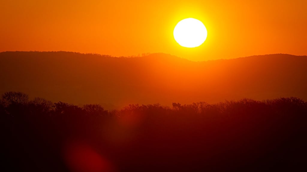 Die Sonne geht bei frostigen Temperaturen am Horizont auf.