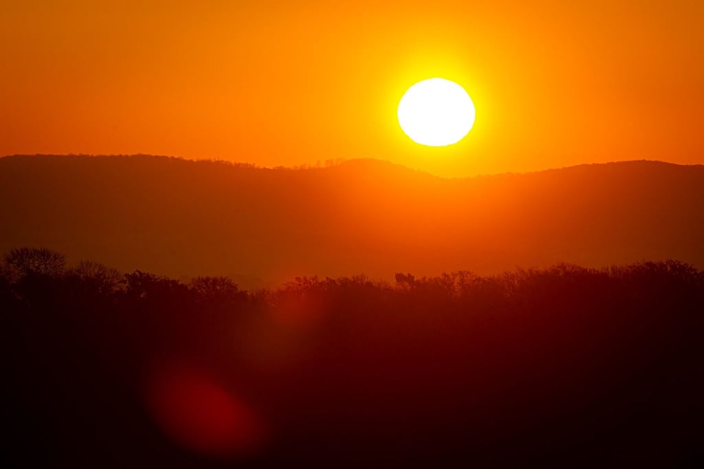Die Sonne geht bei frostigen Temperaturen am Horizont auf.