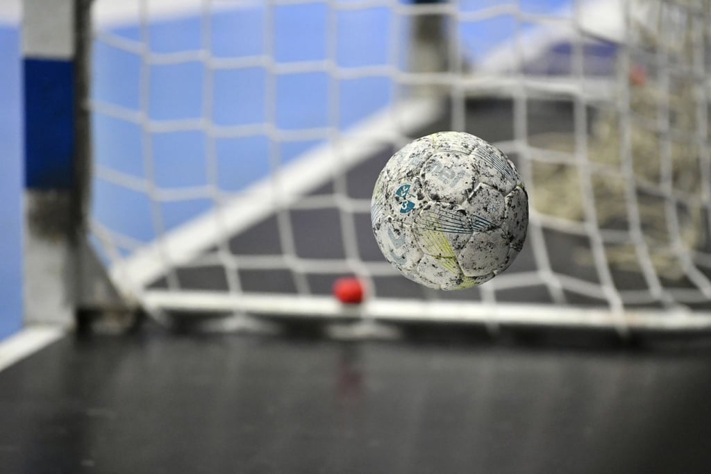 Ein Handball springt vom Boden auf.