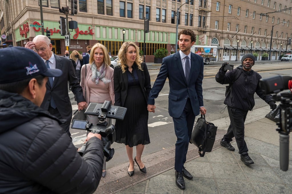 Umringt von Reportern betritt Elizabeth Holmes (M) gemeinsam mit ihrem Partner Billy Evans (r) und ihren Eltern das Gerichtsgebäude im kalifornischen San Jose.