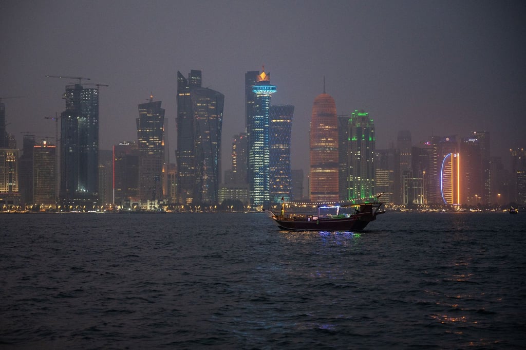 Ein traditionelles Holzschiff, Dhow genannt, fährt am Abend in der Bucht vor der katarischen Hauptstadt Doha.