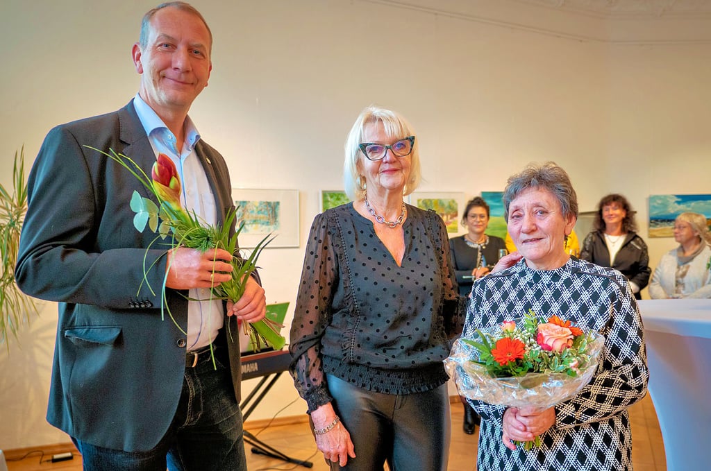 Gommerns Bürgermeister Jens Hünerbein zeigte sich in seiner Laudatio begeistert über die reiche und kreative Schaffenskraft der Kulturwerkstatt. Blumen erhielt auch Brunhilde Schmehl (r.). Der langjährigen Leiterin der Kulturwerkstatt wurde von Ausstellungsleiterin Marion John (Mitte) für ihre unermüdliche Arbeit gedankt.