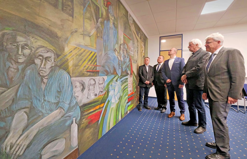 Nicht mehr an der Treppe, sondern als Denkanstoß im Besprechungszimmer hängt das Wandbild von Bernt Wilke (2.v.r.).