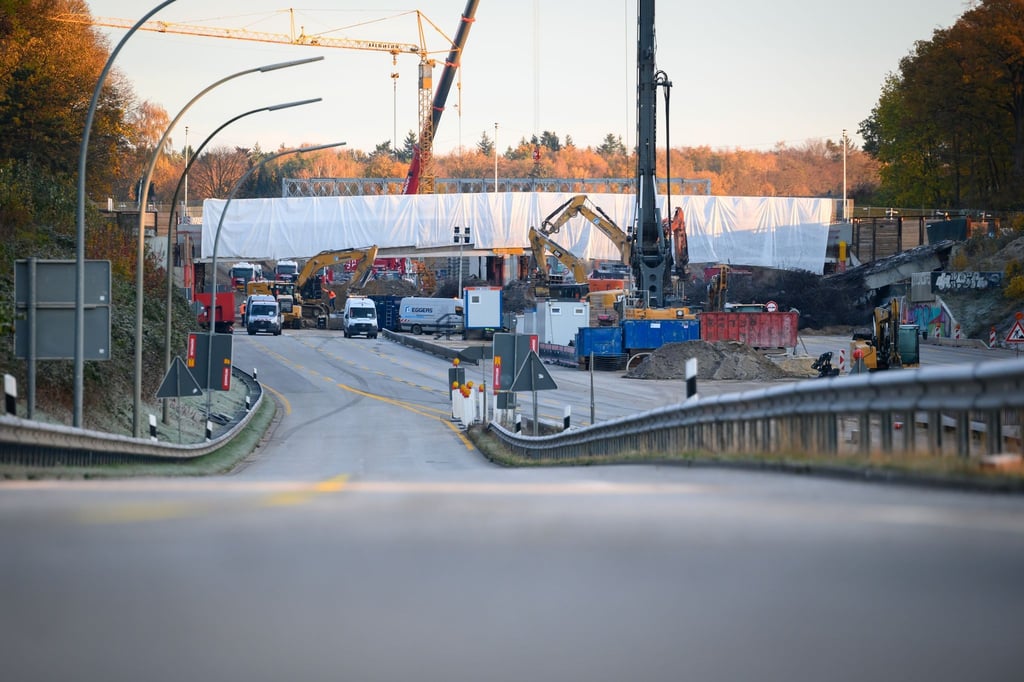 Bagger, Kräne und weitere Baufahrzeuge arbeiten an Brücken über die A7.