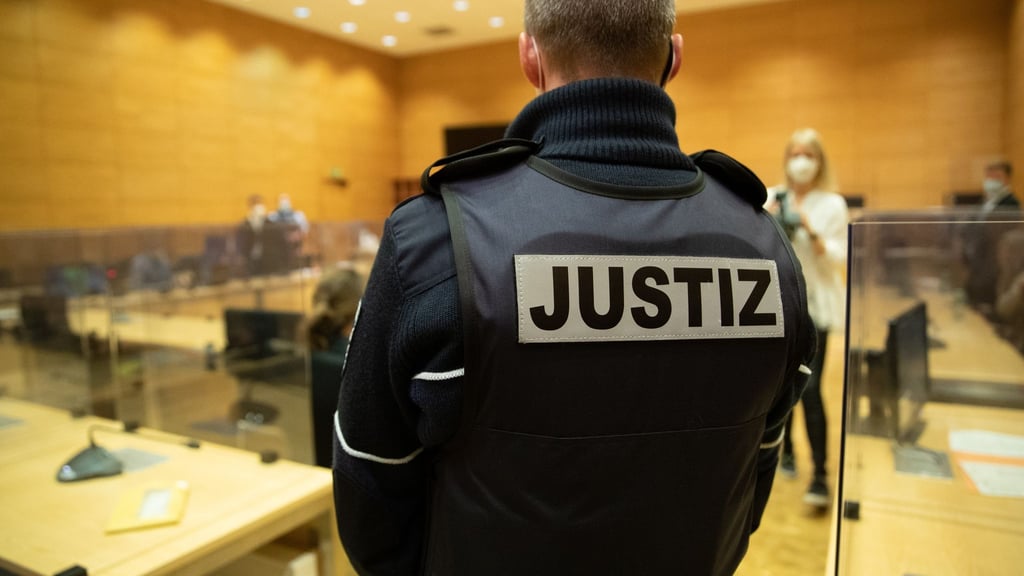 Ein Justizbeamter steht in einem Gerichtssaal.