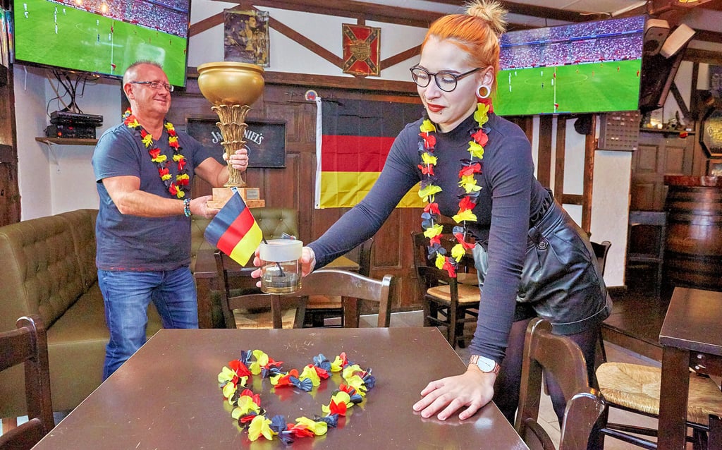 Jörg Gutbier und Sarah Blechta schmücken den Gastraum ihrer Bierkneipe für das WM-Spiel.