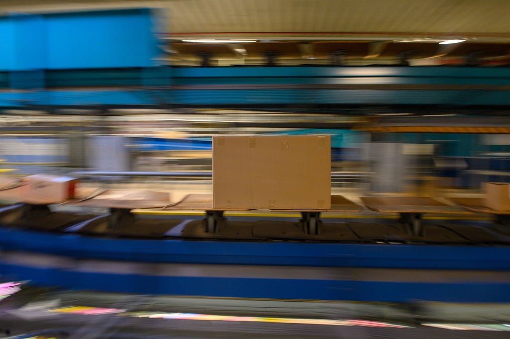 Pakete fahren auf einem Fließband durch das DHL-Paketzentrum in Magdeburg.