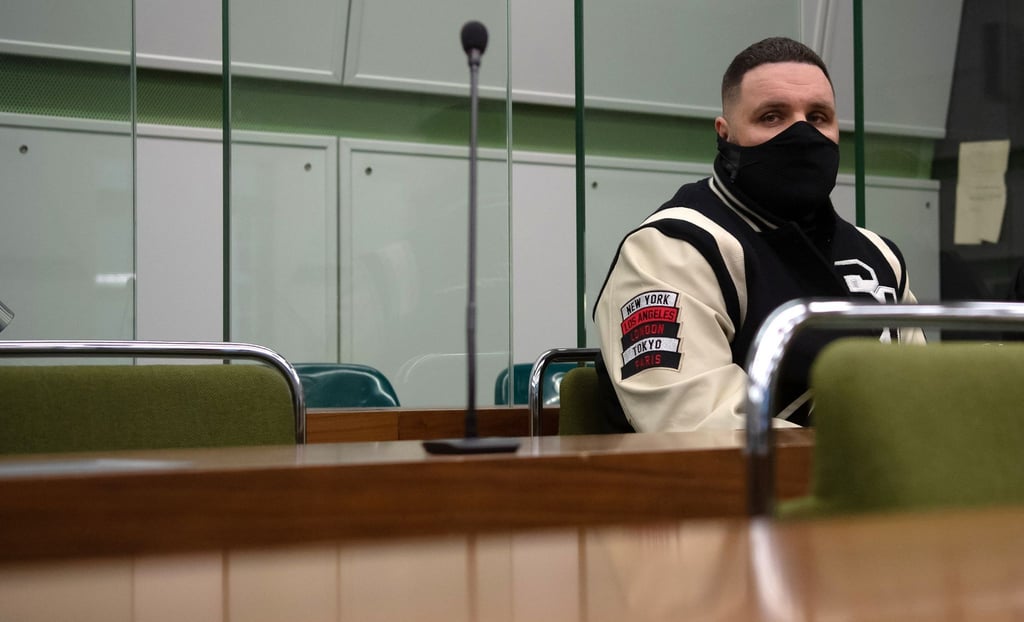 Rapper Fler sitzt in einem Gerichtssaal.
