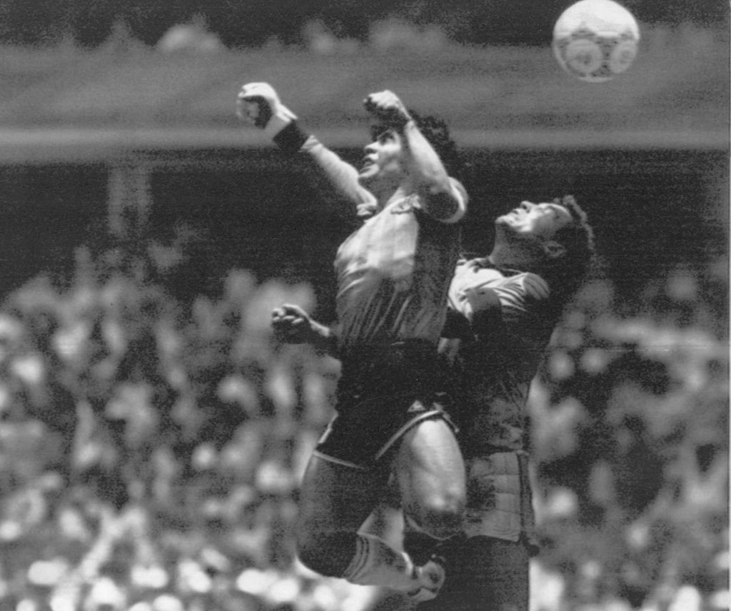 Diego Maradona (l) steigt gegen den englischen Torwart Peter Shilton hoch und erzielt das Tor, das als „Hand Gottes“ bekannt wurde.