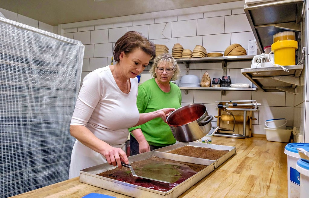Michaela Kreisel (li.), assistiert von Simone Guß, baut den Riesendominostein für den Wörlitzer Advendsmarkt mit Himbergeleefüllung und Marzipan.
