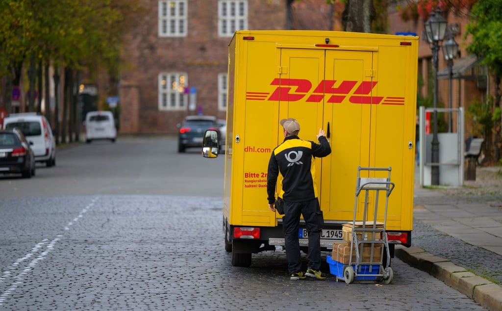Ein Zusteller entlädt ein Fahrzeug von DHL in Lüneburg.