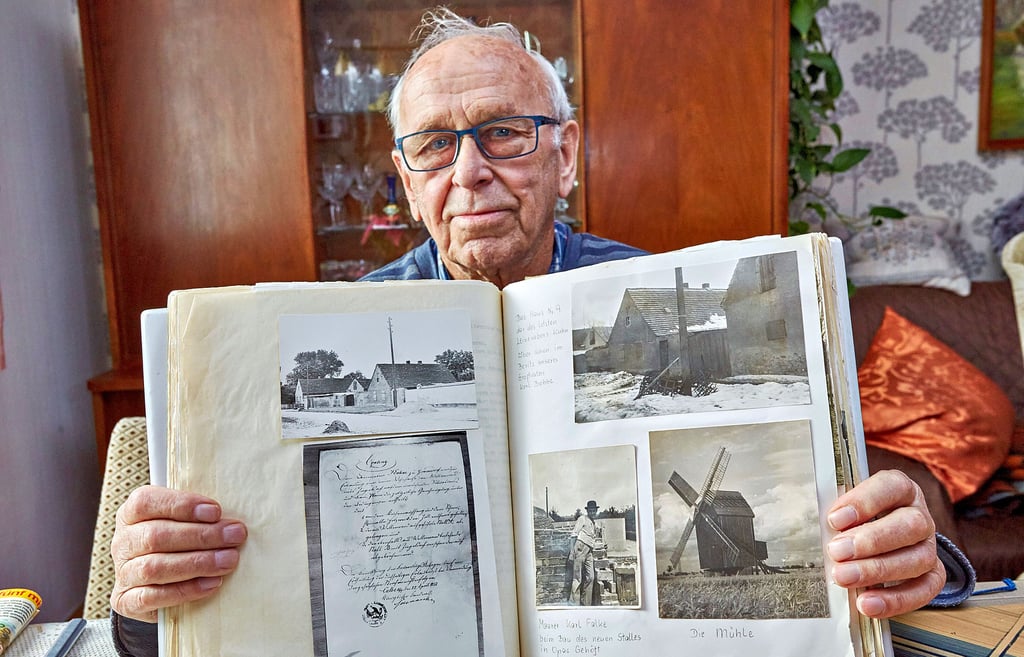 Arno Bobbe zeigt sein Fotoalbum mit dem Mühlenfoto, das er selbst als junger Mann geschossen hat. Dieses Bild schenkte er einst dem letzten Müller, der sich alljährlich auf besondere Weise dafür bedankte.