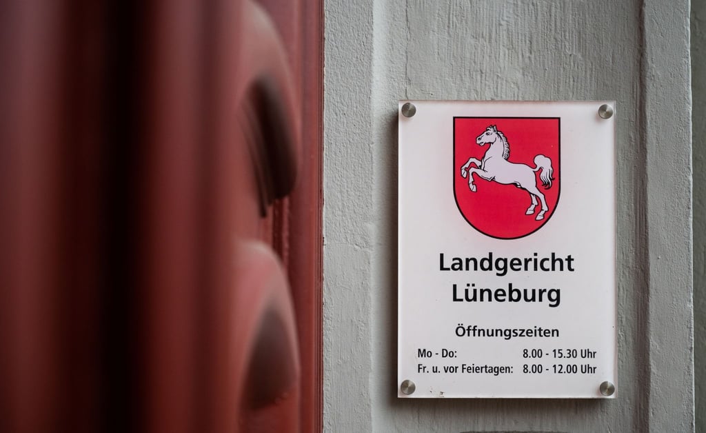 Ein Schild mit Öffnungszeiten hängt am Eingang des Landgerichts Lüneburg.