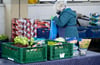 Ehrenamtliche Helfer der Münchner Tafel sortieren an der Ausgabestelle am Großmarkt in München Lebensmittel für die Gäste.
