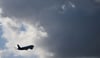 Ein Flugzeug fliegt nach seinem Sart am Flughafen München auf dunkle Wolke zu.