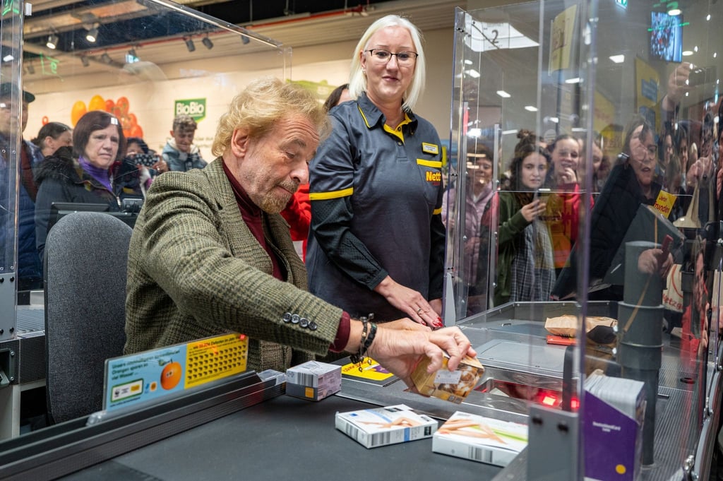 Thomas Gottschalk an einer Supermarkt-Kasse, das Geld aus der Aktion kommt sozialen Zwecken zugute.