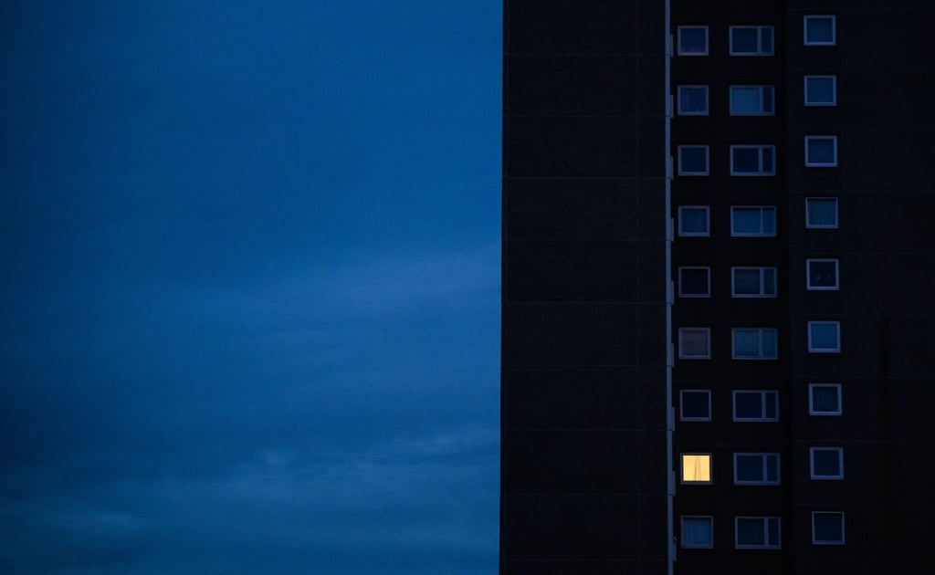 Licht brennt nur in einer Wohnung eines Mehrfamilienhauses.