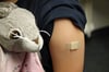 Ein Pflaster klebt nach der Corona-Impfung in Essen auf dem Arm eines Mädchens.