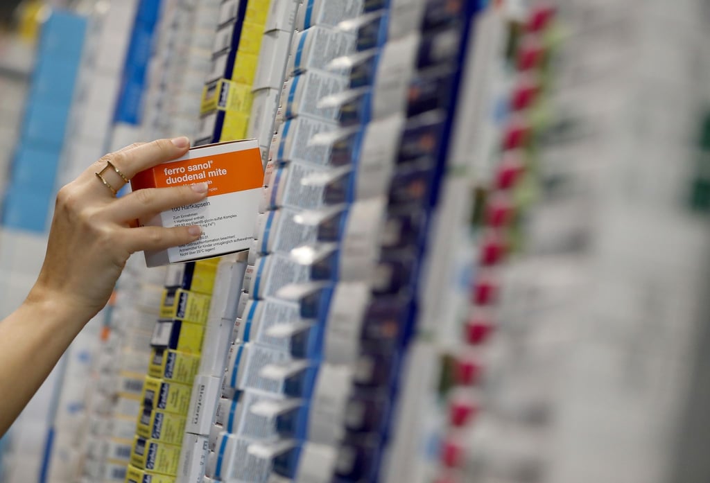 Eine Frau sortiert in einem Logistik Zentrum der Versandapotheke DocMorris Medikamente.