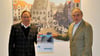 Rainer Gerloff, Chef der Halberstadtwerke (links), übergibt einen Ausstellungskalender an Werner Reinhardt, Vorstand der Halberstädter Bürgerstiftung.