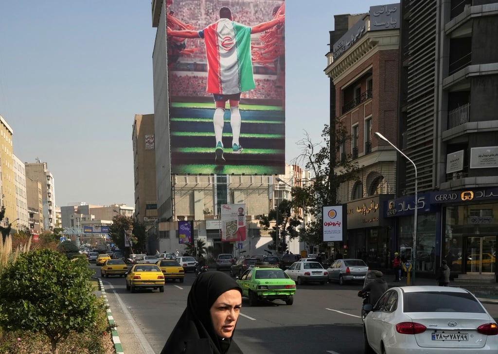Ein Plakat zeigt einen Fußballspieler mit der Nationalflagge an einem Gebäude in Teheran.