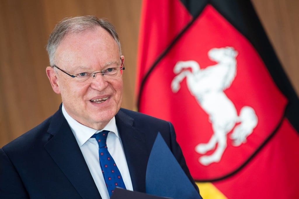 Stephan Weil (SPD), Ministerpräsident von Niedersachsen, steht vor der Landesfahne von Niedersachsen.