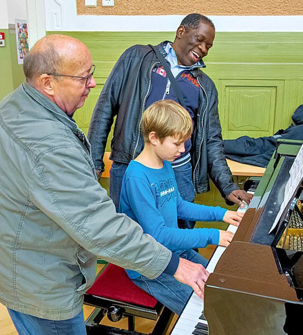 Spontan sechhändig am Klavier: Terrance Ngassa mit Rolf Lachmann und dem zehnjährigen Benjamin Kraft