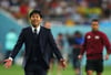 Japans Trainer Hajime Moriyasu breitet zum Spielende lachend die Arme aus.
