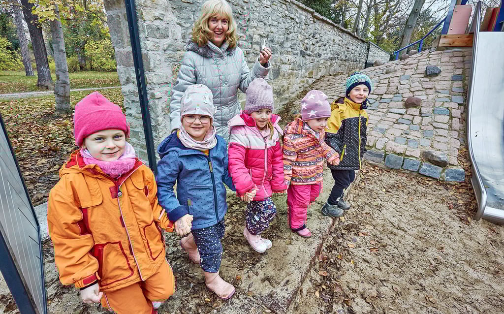 Leiterin Birgit Schmidt und die Kinder der Kita „Benjamin Blümchen“ haben den Schlüssel zum Glück − den direkten Zugang zum Stadtpark.