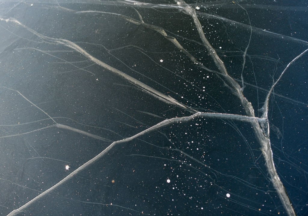 Risse durchziehen die Eisschicht auf dem zugefrorenen Schwarzen See.
