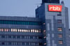 Das beleuchtete Logo des Senders Rundfunk Berlin-Brandenburg an der Fassade am Sitz des Senders.