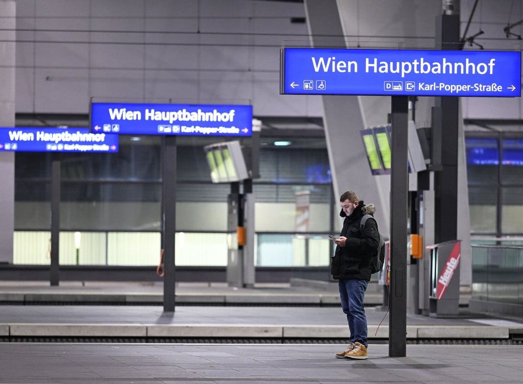 Ein Mann blick auf sein Smartphone an einem Bahnsteig im Hauptbahnhof Wien.