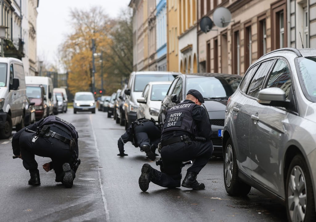 Polizisten suchen in der Nähe des Tatortes in Krefeld nach Spuren.