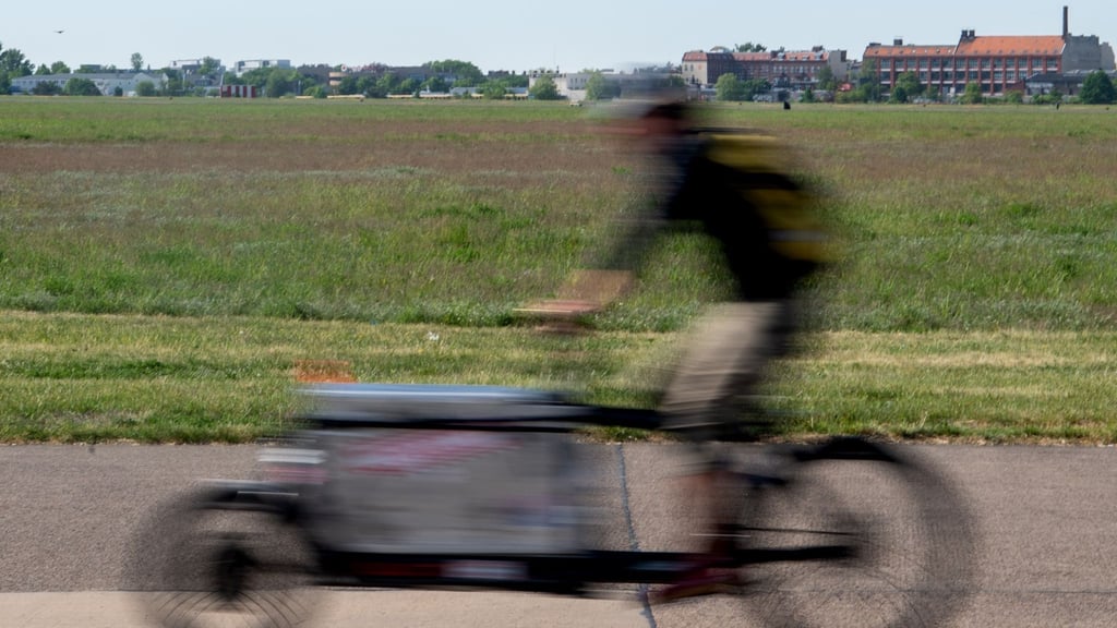 Ein Mann fährt beim sonnigen Wetter auf einem Lastenrad.